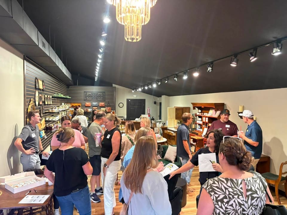 A crowded meetup in a boutique shop with a chandelier and track lighting